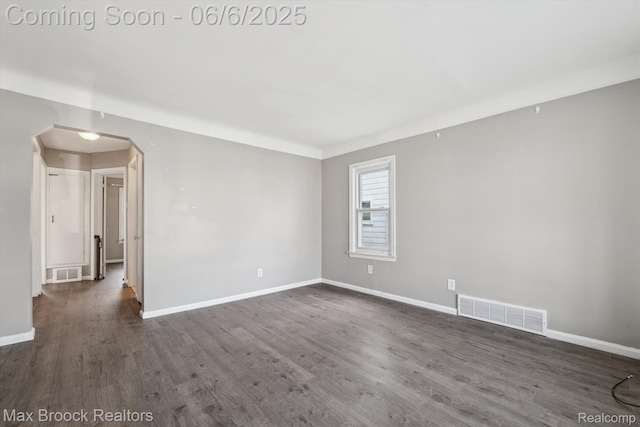 21426 Syracuse Ave, Warren, MI 48091 - unfurnished room with arched walkways, dark wood finished floors, and baseboards
