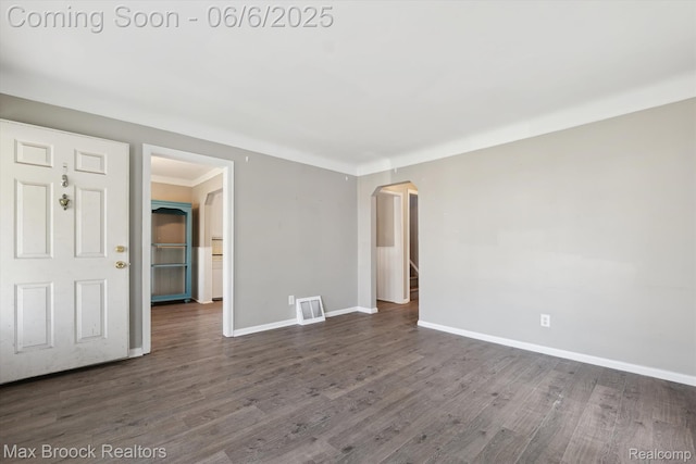 21426 Syracuse Ave, Warren, MI 48091 - empty room with arched walkways, dark wood-style floors, and baseboards