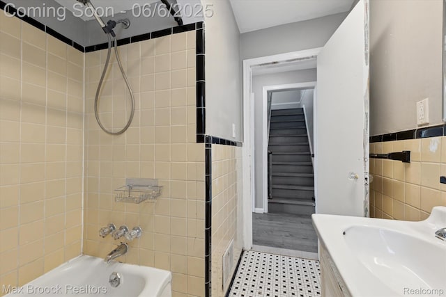 21426 Syracuse Ave, Warren, MI 48091 - full bath with tile walls, a sink, bathtub / shower combination, and wainscoting