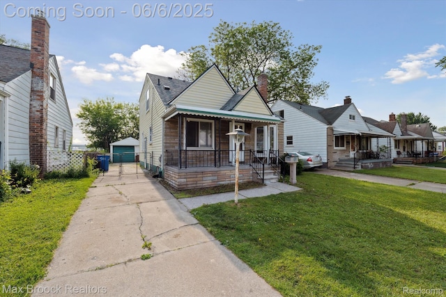 21426 Syracuse Ave, Warren, MI 48091 - bungalow-style home with covered porch, a front yard, an outdoor structure, and a garage