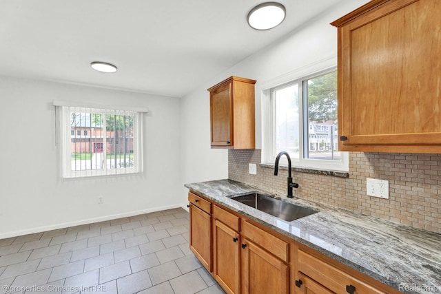 244 E Woodward Heights Blvd, Hazel Park, MI 48030 - kitchen featuring a sink, light stone countertops, baseboards, decorative backsplash, and light tile patterned floors