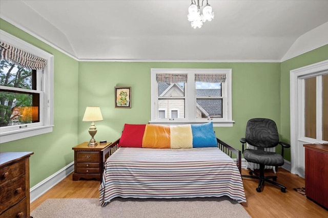 244 Paris Ave SE, Grand Rapids, MI 49503 - bedroom featuring lofted ceiling, multiple windows, wood finished floors, baseboards, and a chandelier