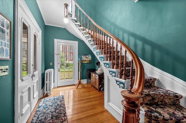 244 Paris Ave SE, Grand Rapids, MI 49503 - entrance foyer featuring stairs, radiator, wood finished floors, crown molding, and baseboards
