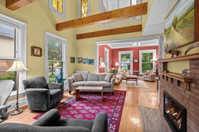 244 Paris Ave SE, Grand Rapids, MI 49503 - living area featuring healthy amount of natural light, wood finished floors, a brick fireplace, and a high ceiling