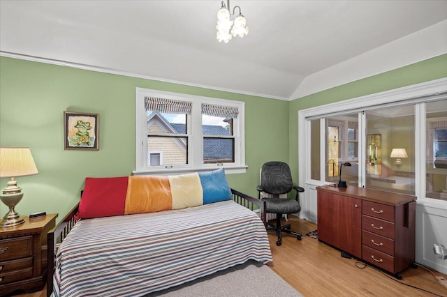 244 Paris Ave SE, Grand Rapids, MI 49503 - bedroom with lofted ceiling, light wood-type flooring, and a chandelier