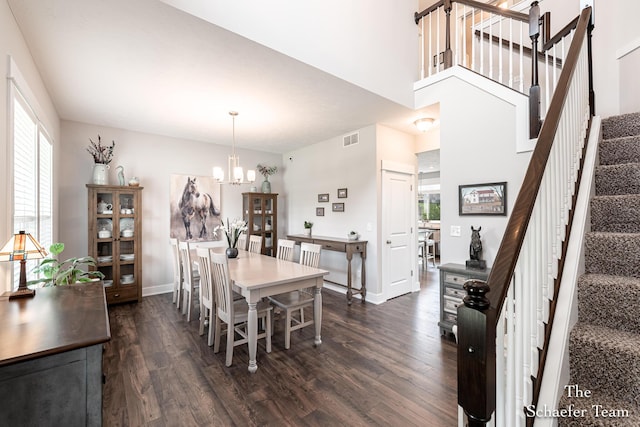 12150 Apple Cart Ln, Lowell, MI 49331 - dining area featuring dark wood-style flooring, a chandelier, stairs, and baseboards
