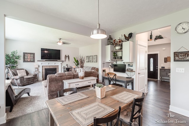 12150 Apple Cart Ln, Lowell, MI 49331 - dining area with ceiling fan, dark wood-type flooring, a fireplace, and baseboards