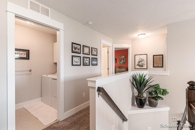 12150 Apple Cart Ln, Lowell, MI 49331 - hallway with an upstairs landing, washing machine and dryer, and baseboards