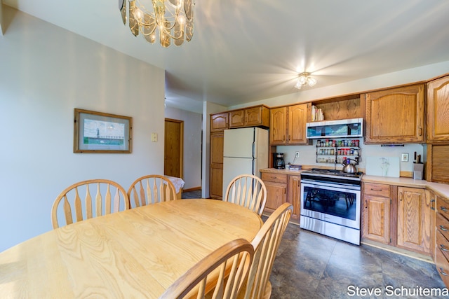 19151 Pine Grove Ct, Spring Lake, MI 49456 - kitchen with stainless steel appliances, a chandelier, light countertops, and brown cabinetry