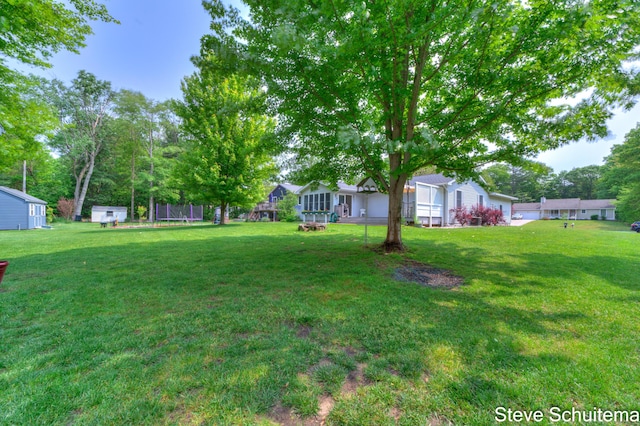 19151 Pine Grove Ct, Spring Lake, MI 49456 - view of grassy yard with a trampoline