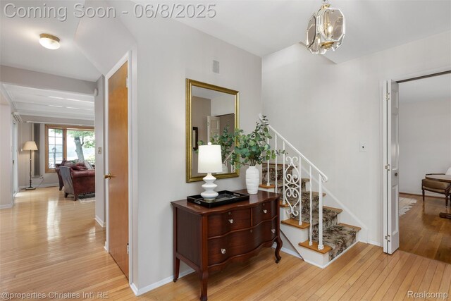 3379 Wormer Dr, Waterford, MI 48329 - staircase featuring wood-type flooring, a chandelier, and baseboards
