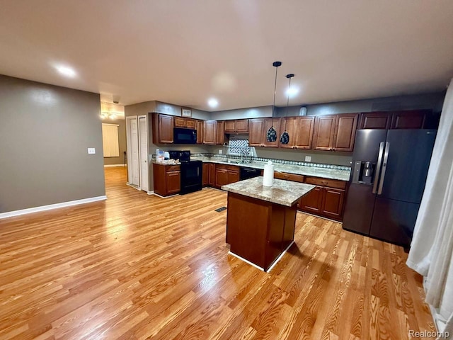 38132 Jamestown Dr, Sterling Heights, MI 48312 - kitchen featuring black appliances, light wood finished floors, hanging light fixtures, baseboards, and a sink