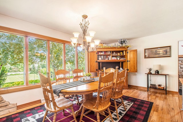 3210 Niles Buchanan Rd, Buchanan, MI 49107 - dining area featuring a chandelier, healthy amount of natural light, light wood finished floors, and baseboards