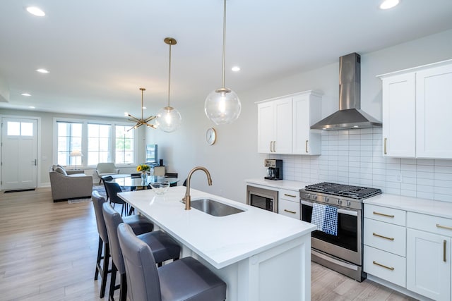 917 Harbor Dr E, Saint Joseph, MI 49085 - kitchen featuring wall chimney range hood, gas range, a sink, light countertops, and decorative backsplash