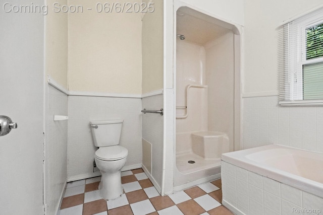 23808 Beierman Ave, Warren, MI 48091 - bathroom featuring tile walls, a shower stall, toilet, wainscoting, and tile patterned floors