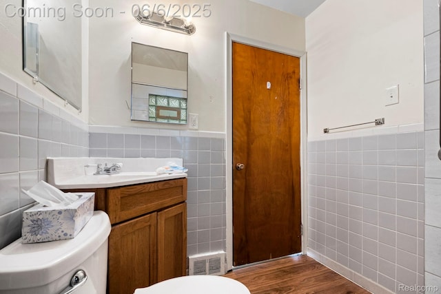 23808 Beierman Ave, Warren, MI 48091 - bathroom with tile walls, toilet, a wainscoted wall, vanity, and wood finished floors