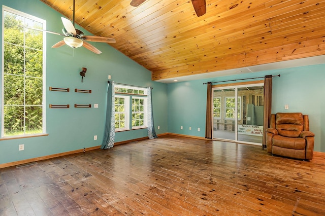 6997 W Woodlea Rd, Oscoda, MI 48750 - unfurnished living room with a ceiling fan, lofted ceiling, hardwood / wood-style floors, healthy amount of natural light, and baseboards
