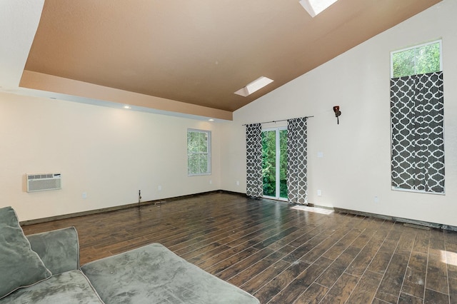 6997 W Woodlea Rd, Oscoda, MI 48750 - unfurnished living room featuring an AC wall unit, healthy amount of natural light, wood finished floors, and high vaulted ceiling