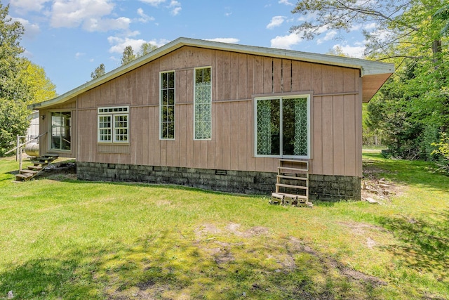 6997 W Woodlea Rd, Oscoda, MI 48750 - view of side of property featuring entry steps, crawl space, and a yard