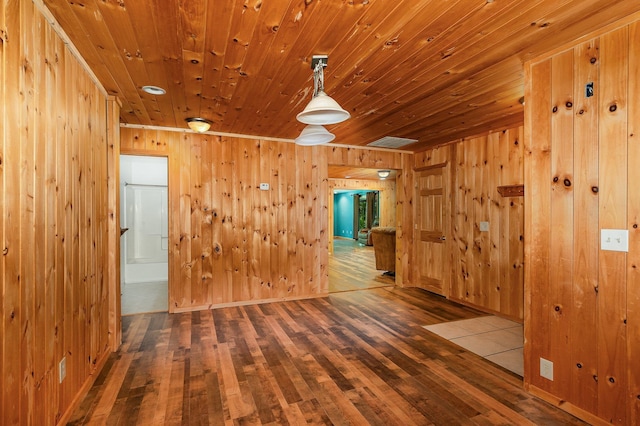 6997 W Woodlea Rd, Oscoda, MI 48750 - spare room featuring wood walls and wood finished floors