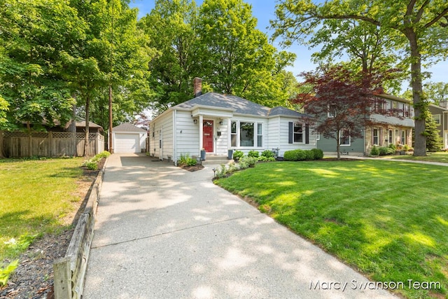 815 Reynard St SE, Grand Rapids, MI 49507 - view of front of house with an outbuilding, a detached garage, a chimney, and concrete driveway