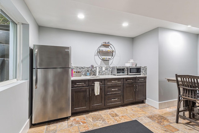 1518 White Pine Ct, Twin Lake, MI 49457 - kitchen featuring appliances with stainless steel finishes, stone tile flooring, baseboards, dark brown cabinets, and light countertops