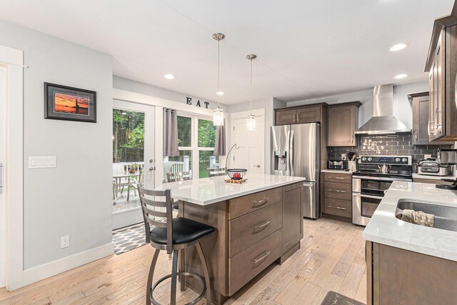 1518 White Pine Ct, Twin Lake, MI 49457 - kitchen with wall chimney range hood, stainless steel appliances, dark brown cabinetry, light wood-style flooring, and recessed lighting