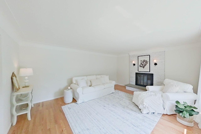 2113 12th St, Wyandotte, MI 48192 - living area with light wood-type flooring, a brick fireplace, and crown molding