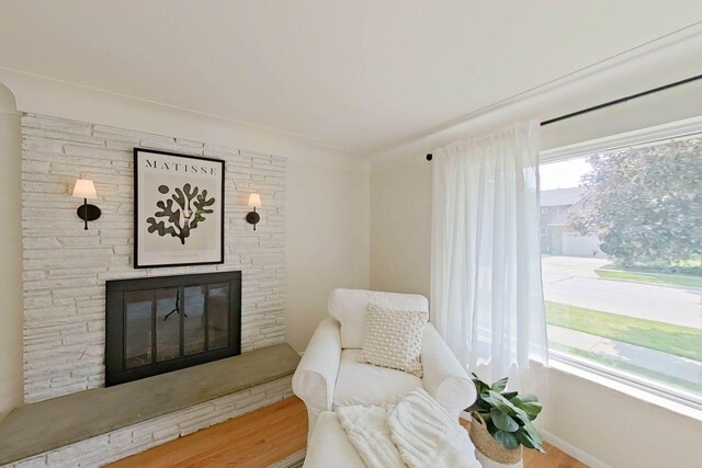 2113 12th St, Wyandotte, MI 48192 - sitting room with a fireplace, wood finished floors, and baseboards