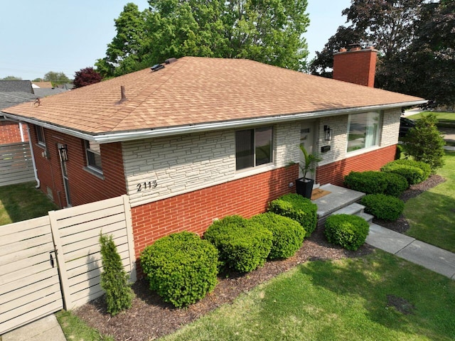 2113 12th St, Wyandotte, MI 48192 - view of front facade with brick siding, a chimney, and a shingled roof