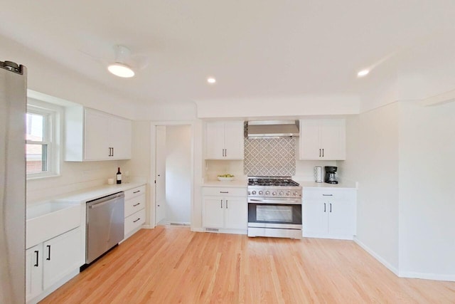 2113 12th St, Wyandotte, MI 48192 - kitchen featuring stainless steel appliances, wall chimney exhaust hood, tasteful backsplash, light wood finished floors, and recessed lighting
