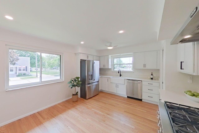 2113 12th St, Wyandotte, MI 48192 - kitchen with stainless steel appliances, a sink, under cabinet range hood, white cabinets, and recessed lighting