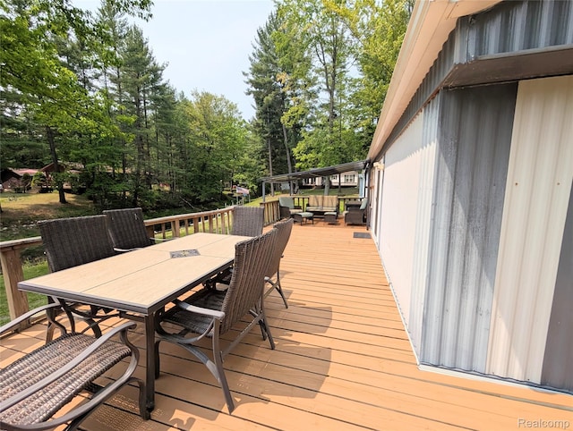 3730 Pinelands Rd, Gladwin, MI 48624 - wooden terrace with outdoor dining area, outdoor lounge area, and view of wooded area
