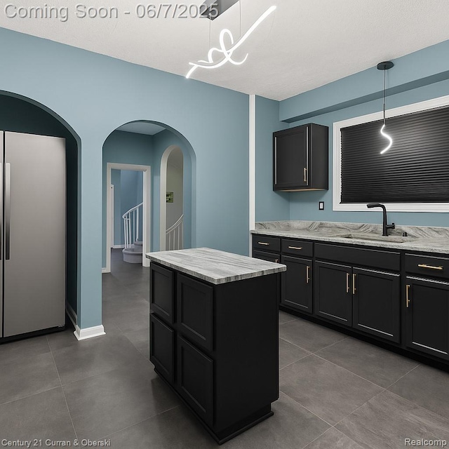 15915 Vaughan St, Detroit, MI 48223 - kitchen featuring a sink, tile patterned flooring, dark cabinetry, and hanging light fixtures