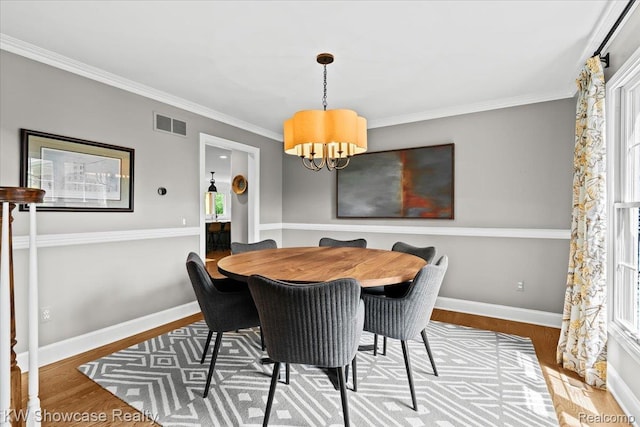 1307 Trillium Ct, Wixom, MI 48393 - dining room featuring healthy amount of natural light, wood finished floors, a chandelier, and ornamental molding