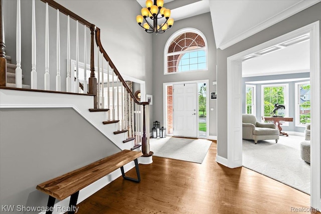 1307 Trillium Ct, Wixom, MI 48393 - foyer entrance with stairway, wood finished floors, a chandelier, and a high ceiling