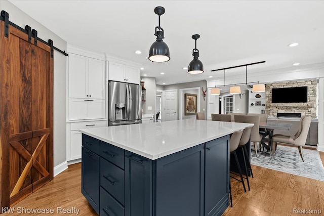 1307 Trillium Ct, Wixom, MI 48393 - kitchen featuring stainless steel refrigerator with ice dispenser, a barn door, white cabinetry, light wood-style flooring, and light countertops