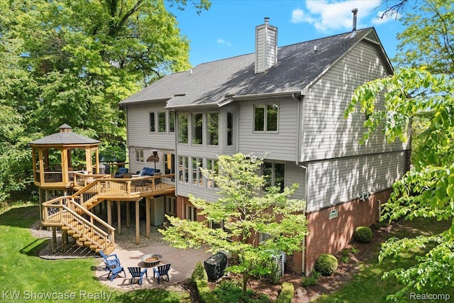 1307 Trillium Ct, Wixom, MI 48393 - back of house featuring a gazebo, a chimney, a deck, an outdoor fire pit, and a patio