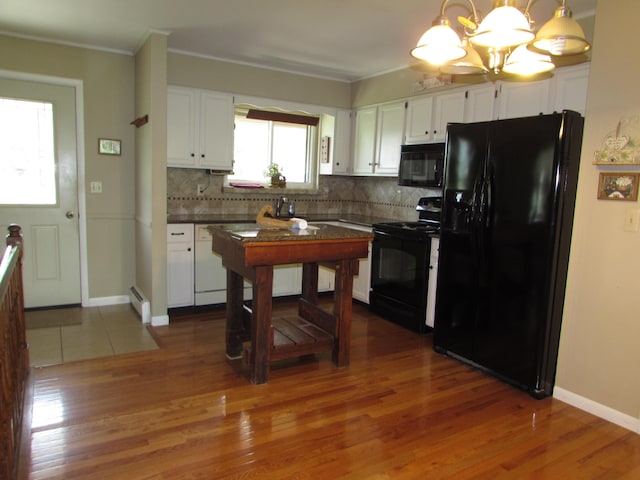 9920 Camridge Ct, South Lyon, MI 48178 - kitchen with black appliances, white cabinetry, backsplash, wood finished floors, and ornamental molding
