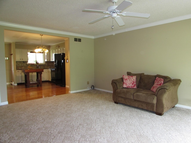 9920 Camridge Ct, South Lyon, MI 48178 - carpeted living room featuring a chandelier, ornamental molding, a ceiling fan, baseboards, and a textured ceiling