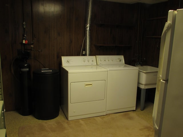 9920 Camridge Ct, South Lyon, MI 48178 - washroom with washing machine and dryer, light colored carpet, and wood walls