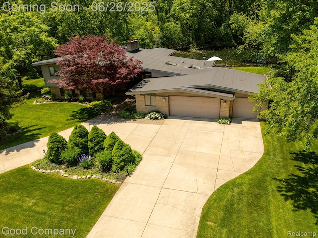 30239 Hickory Ln, Franklin, MI 48025 - view of front of home featuring concrete driveway, a garage, a front lawn, and brick siding