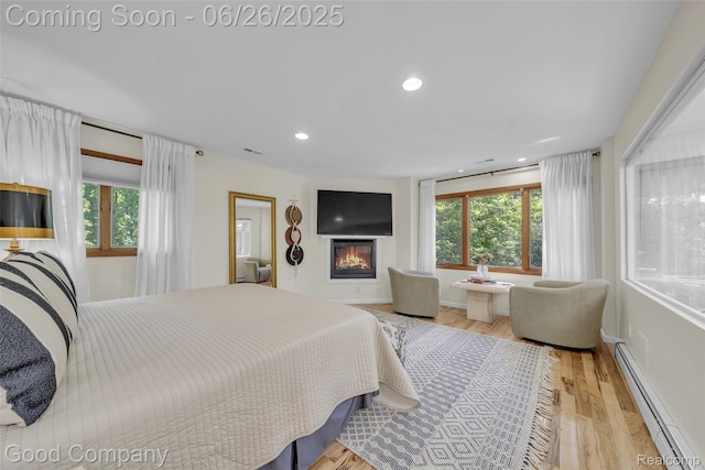 30239 Hickory Ln, Franklin, MI 48025 - bedroom with baseboard heating, a glass covered fireplace, wood finished floors, and recessed lighting