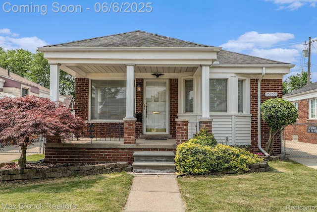 15255 Horger Ave, Allen Park, MI 48101 - view of front of home featuring brick siding, a porch, roof with shingles, and a front lawn