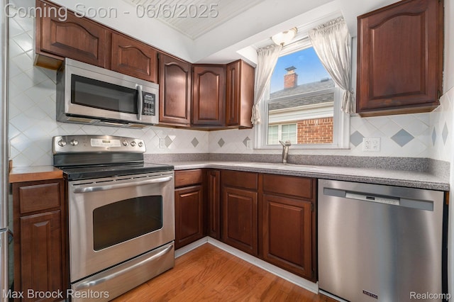 15255 Horger Ave, Allen Park, MI 48101 - kitchen with appliances with stainless steel finishes, a sink, light wood-style floors, and backsplash