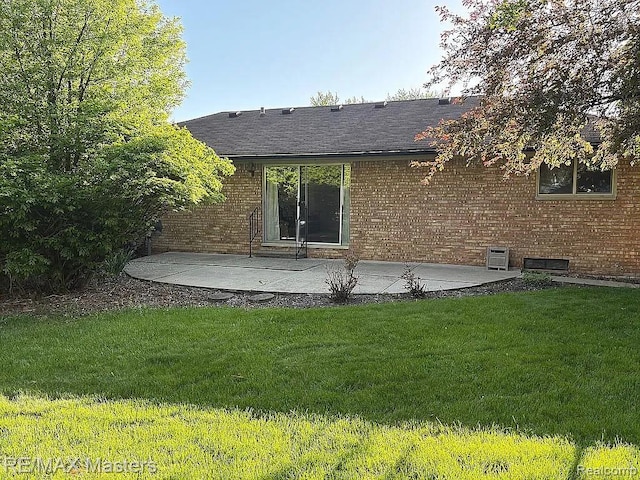 43242 Barchester Rd, Canton, MI 48187 - rear view of property featuring a patio area, a yard, brick siding, and roof with shingles