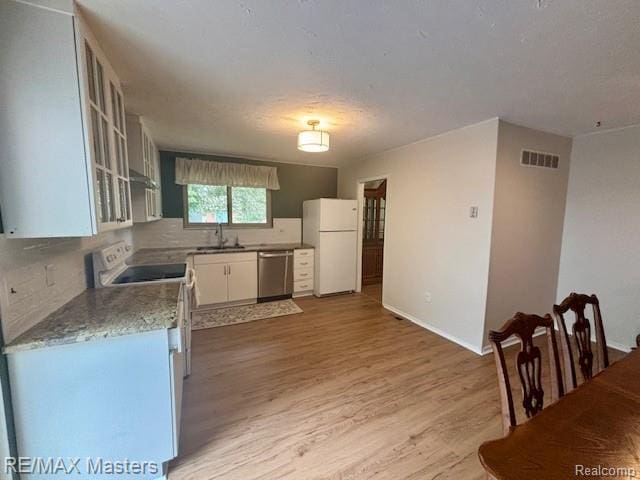 43242 Barchester Rd, Canton, MI 48187 - kitchen with white appliances, a sink, white cabinets, light wood-style floors, and baseboards