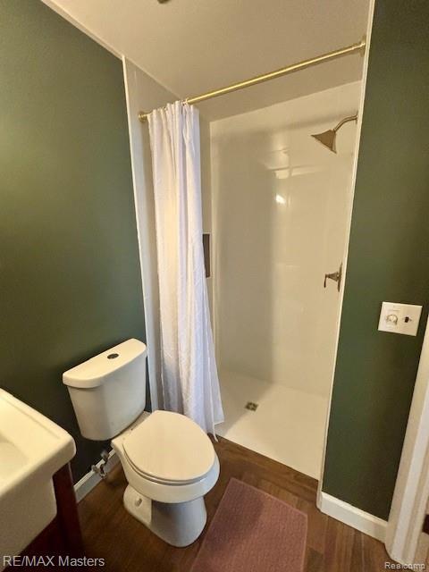 43242 Barchester Rd, Canton, MI 48187 - bathroom featuring toilet, a shower with curtain, wood finished floors, and baseboards