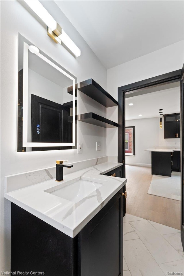 17169 Griggs St, Detroit, MI 48221 - kitchen featuring dark cabinetry, a sink, light stone countertops, open shelves, and light marble finish flooring
