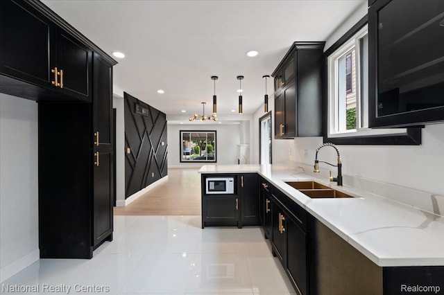 17169 Griggs St, Detroit, MI 48221 - kitchen with dark cabinetry, a sink, white microwave, light tile patterned floors, and recessed lighting